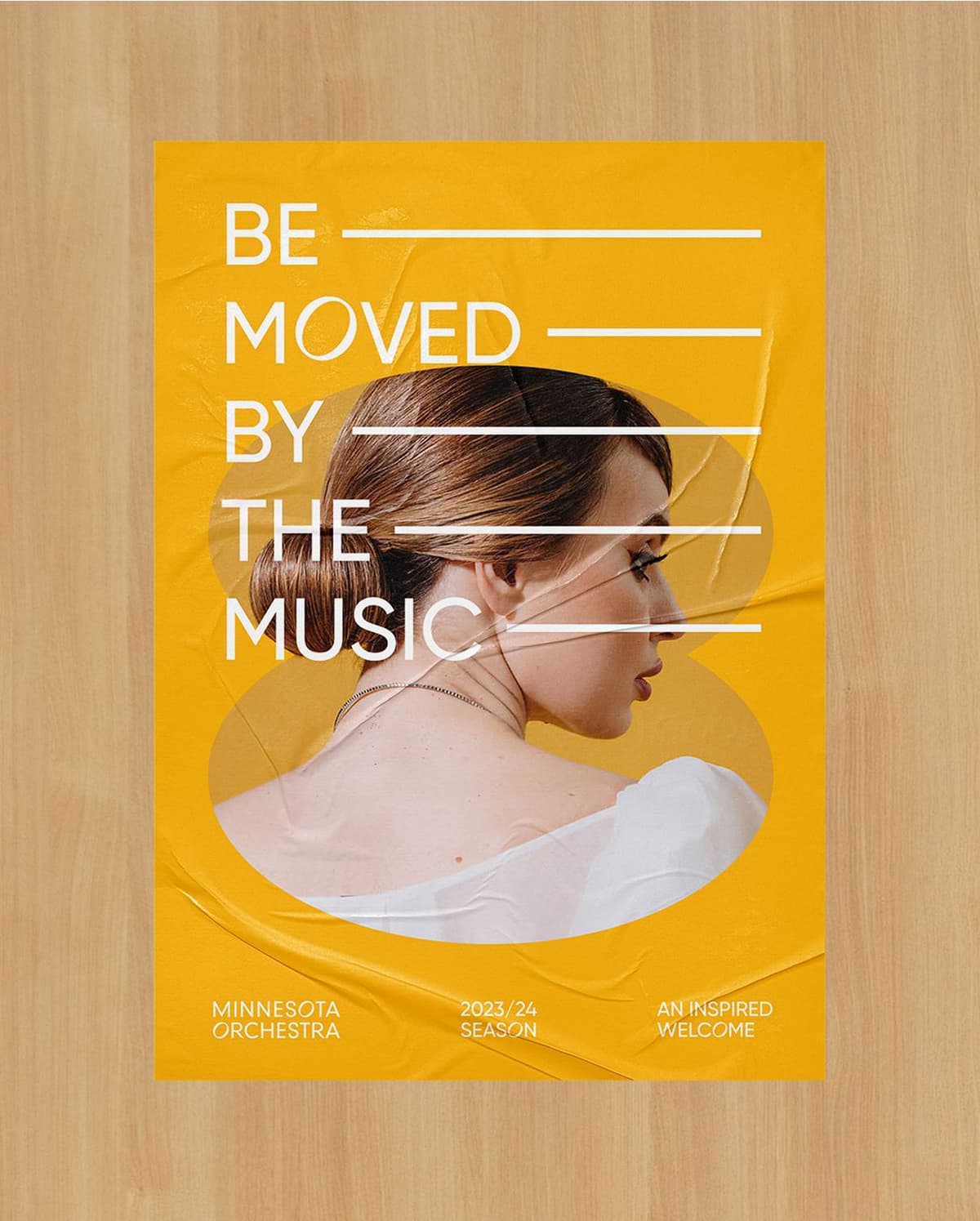 Poster with a mustard yellow background featuring a side profile of a woman with brown hair in a bun, wearing a white top. Overlaid text reads "Be moved by the music" with white lines after each phrase. Additional text at the bottom says "Minnesota Orchestra 2023/24 Season An Inspired Welcome."