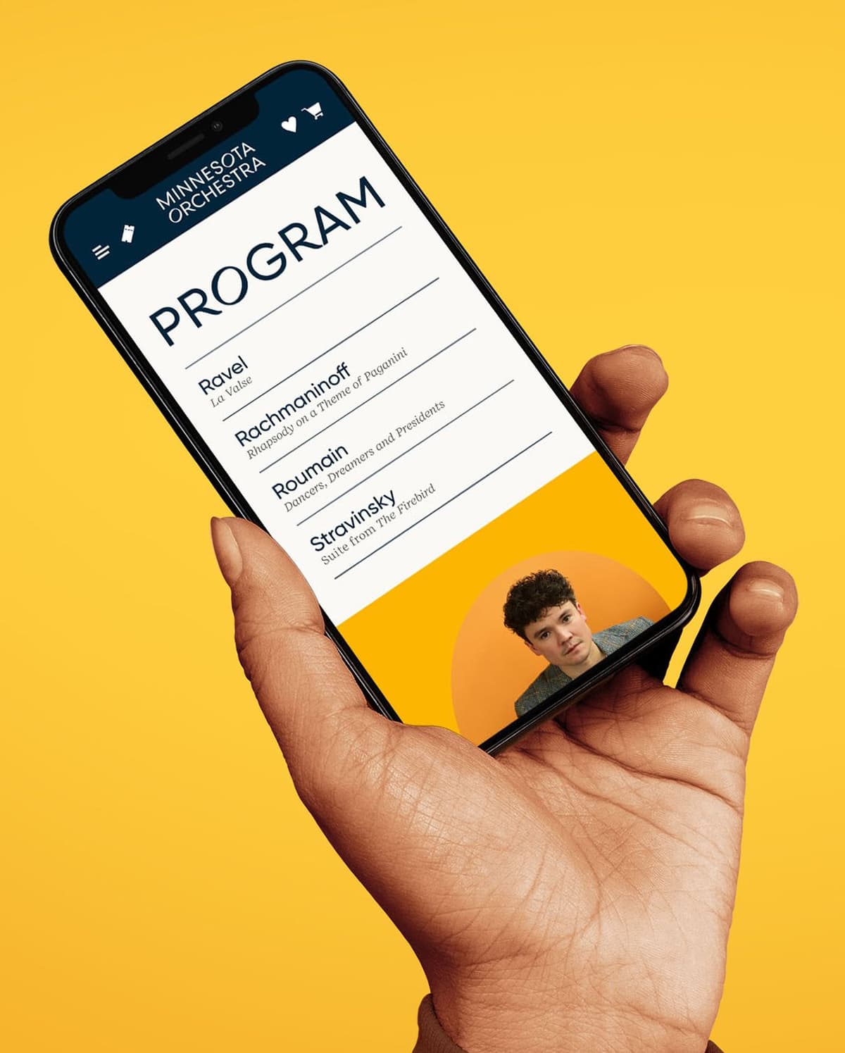 Hand holding a smartphone displaying the Minnesota Orchestra program against a yellow background. The program lists four composers and pieces: Ravel - La Valse, Rachmaninoff - Rhapsody on a Theme of Paganini, Roumain - Dancers, Dreamers and Presidents, and Stravinsky - Suite from The Firebird. There is a small circular image of a young man with curly hair at the bottom of the screen.