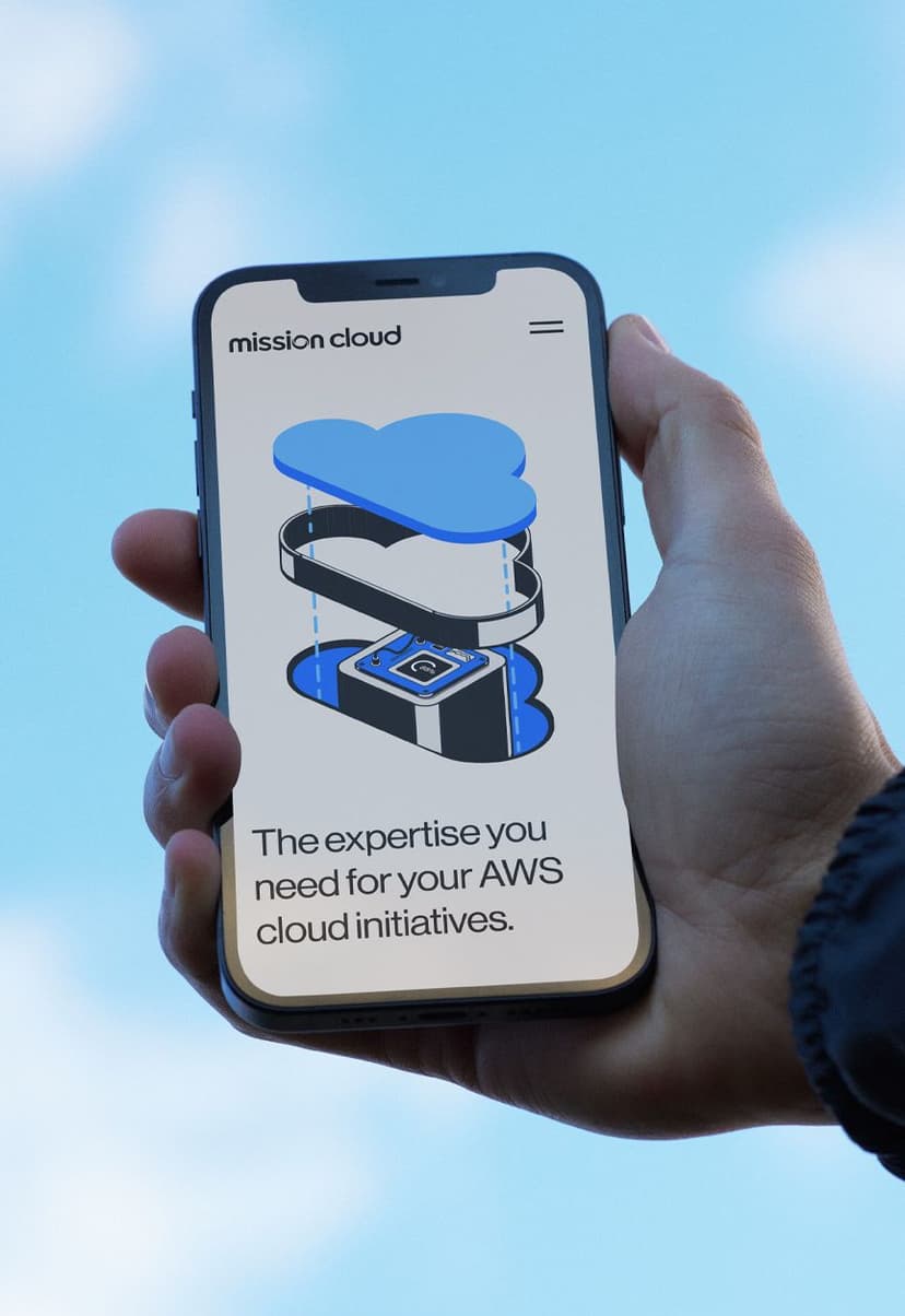 Hand holding a smartphone displaying a website with the text "mission cloud" and "The expertise you need for your AWS cloud initiatives," along with a blue and black cloud-shaped graphic.