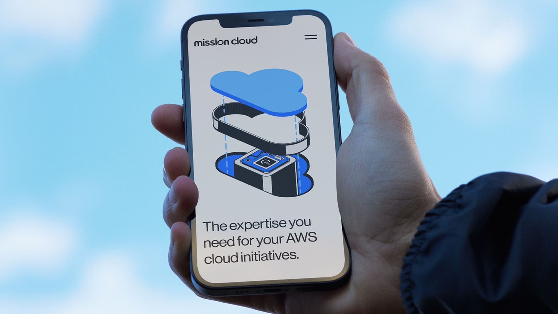 Hand holding a smartphone displaying a webpage with the logo "mission cloud," an illustration of a cloud with server components, and the text "The expertise you need for your AWS cloud initiatives."